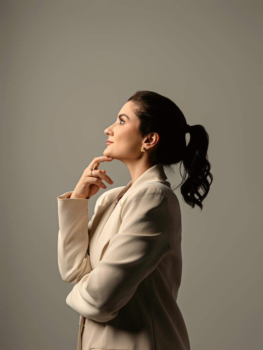 Retrato de perfil da Dra. Marcella, olhando para cima com expressão serena e atenta